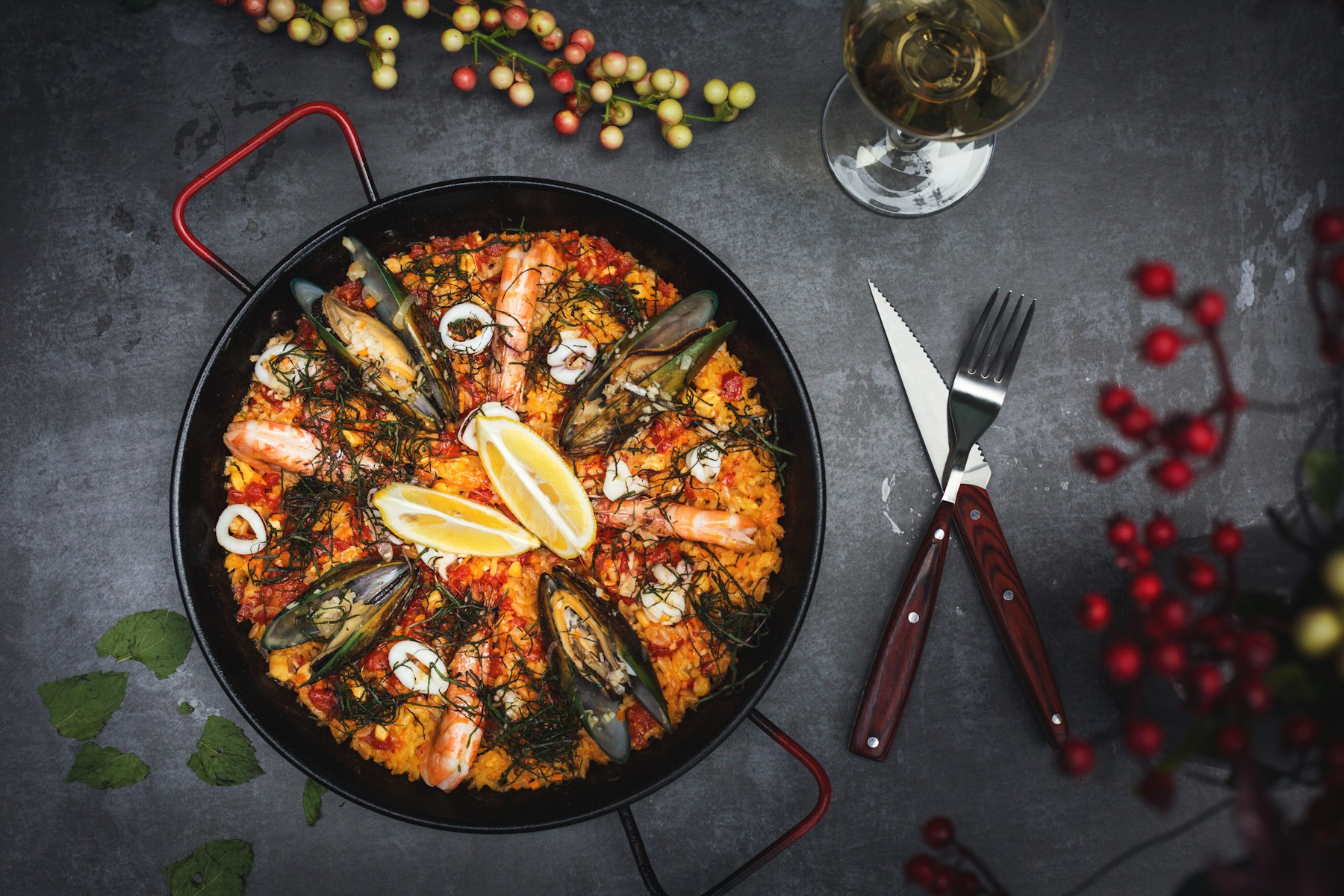 Paella de mariscos recién hecha en paellera, con limón y mejillones