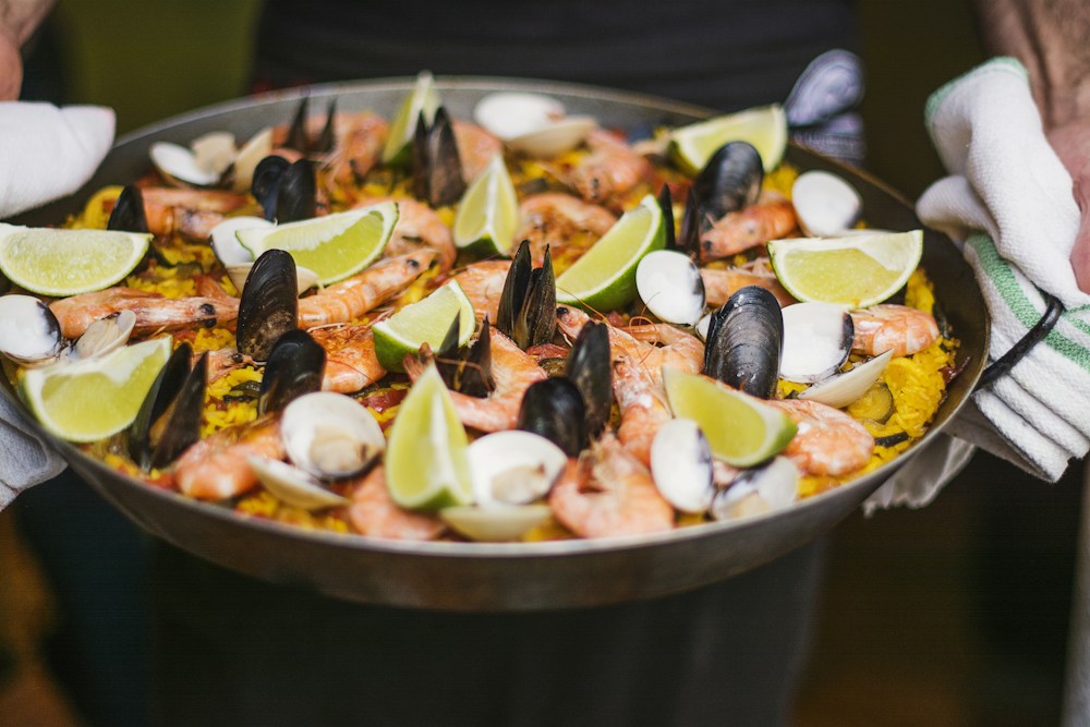 Paella de mariscos a domicilio con camarones frescos y limón